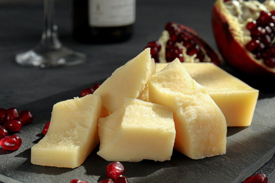 Cheeses on display with wine in the background